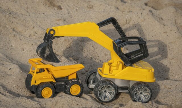 toy, excavator, sand, dumper, playing in sand, yellow color, construction site, kids' play, model, outdoor activity, building, beach toys, child's imagination, toy vehicles, outdoor play, wheels, small vehicle, interactive play, kids' excavator, play set